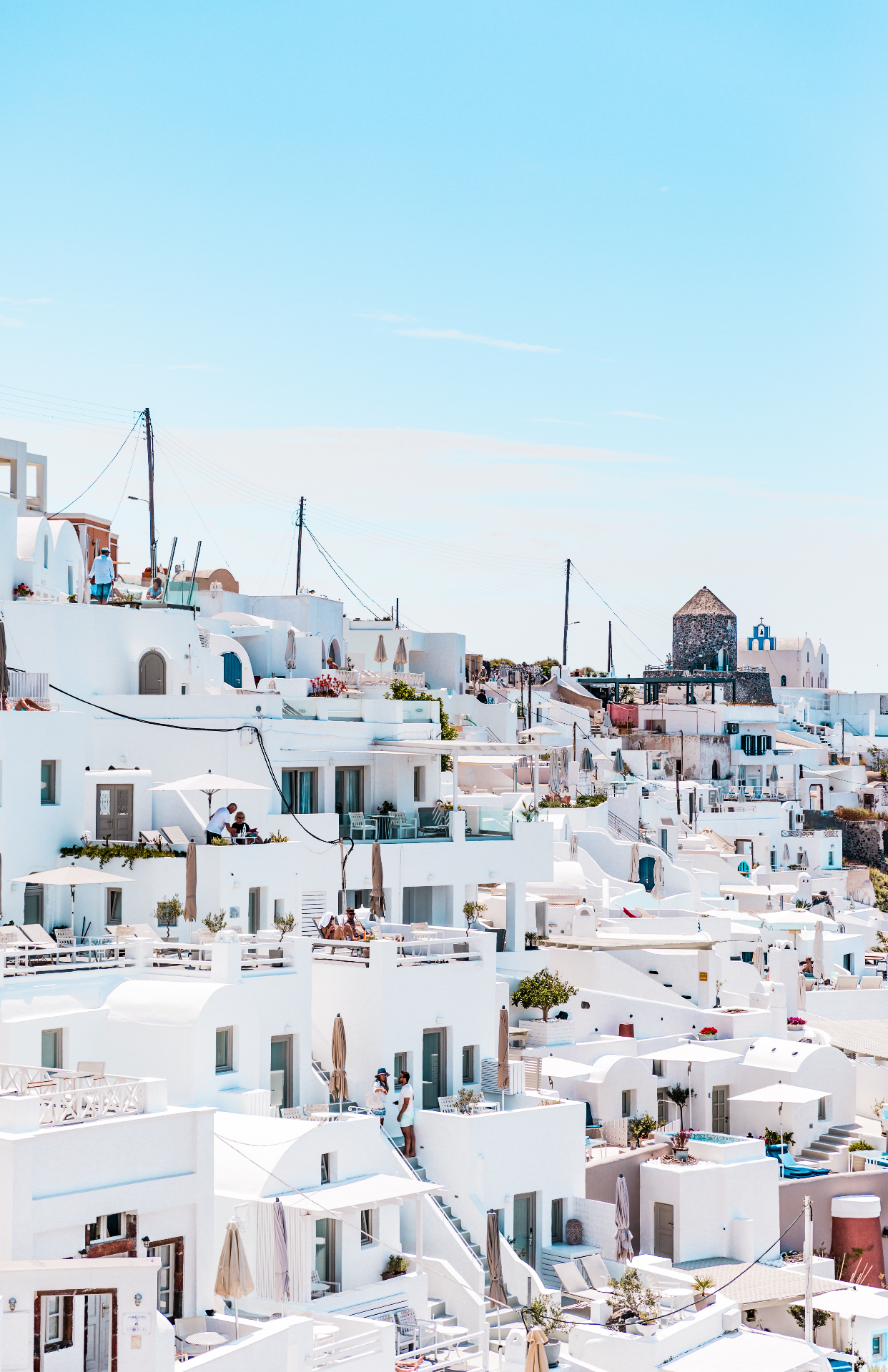 Witgekalkt Santorini-dorp dat tegen de heuvels op klimt